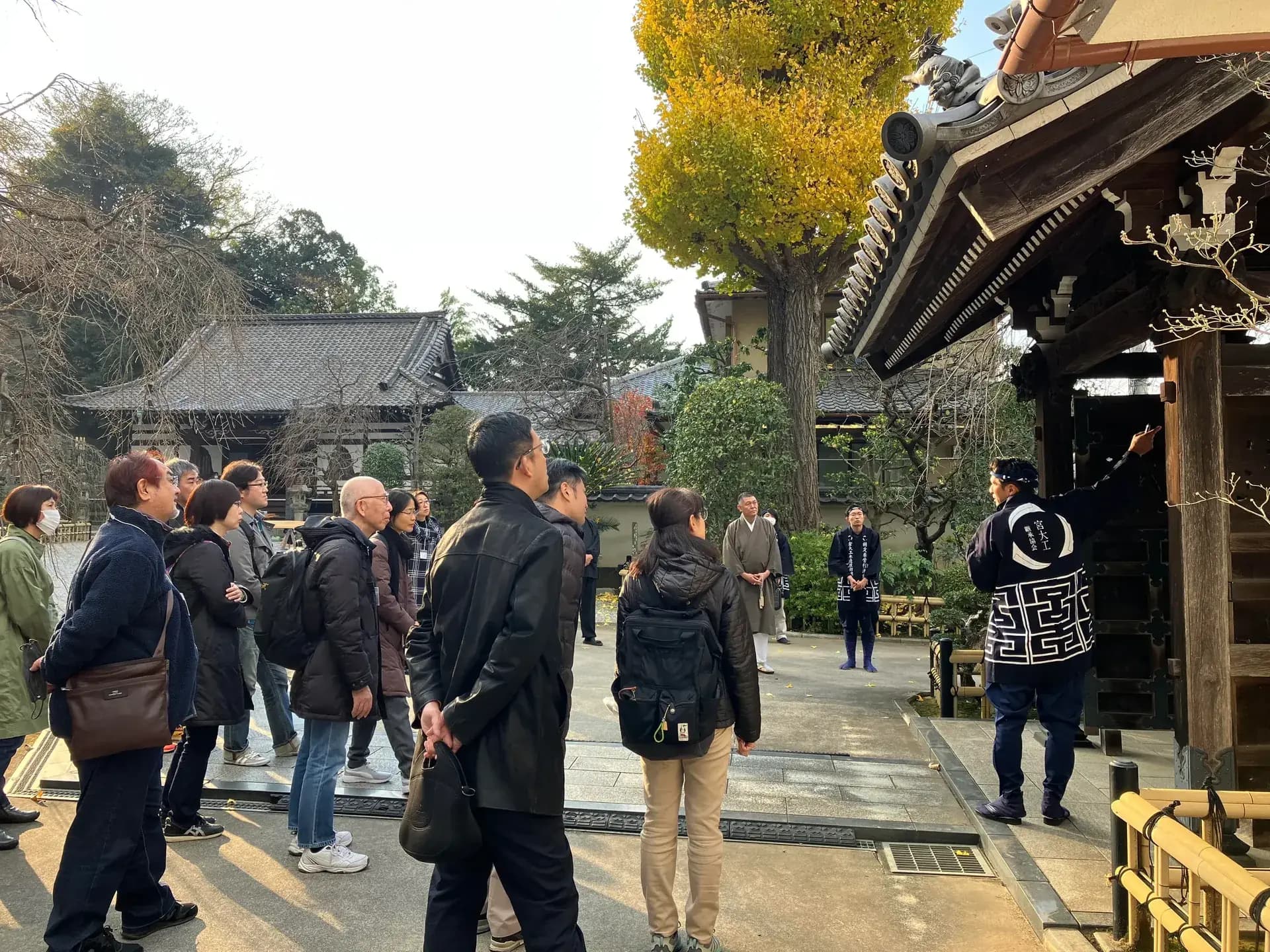 社寺で説明を聞く人々