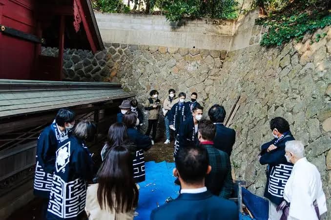建築を囲み説明を受ける人々