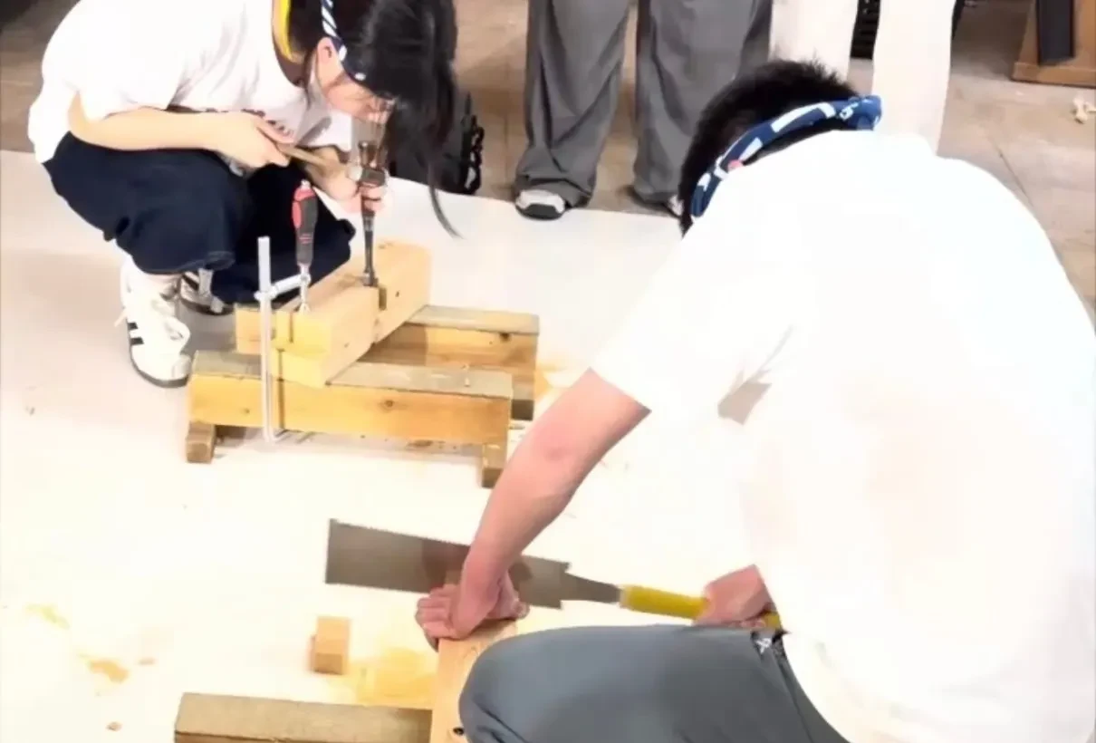 鋸と鑿で木材を刻む実習に取り組む若手